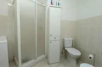a white bathroom with a toilet and a shower at Rocamare in Cannes
