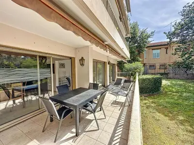 a patio with a black table and chairs at 130m2 Terrasses, Jardin, 4chambres, Climatisation in Cannes
