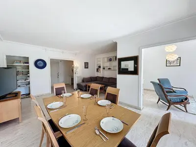 a dining room and living room with a table and chairs at 130m2 Terrasses, Jardin, 4chambres, Climatisation in Cannes