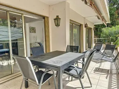 a dining table and chairs on a patio at 130m2 Terrasses, Jardin, 4chambres, Climatisation in Cannes