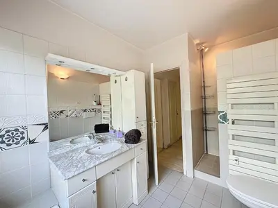 a white bathroom with a sink and a mirror at 130m2 Terrasses, Jardin, 4chambres, Climatisation in Cannes