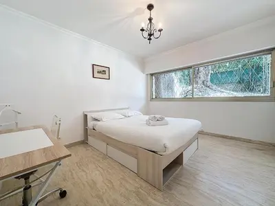 a bedroom with a bed and a desk and a window at 130m2 Terrasses, Jardin, 4chambres, Climatisation in Cannes