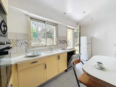 a kitchen with a sink and a window and a table at 130m2 Terrasses, Jardin, 4chambres, Climatisation in Cannes