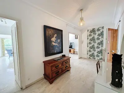 a living room with a dresser and a painting on the wall at 130m2 Terrasses, Jardin, 4chambres, Climatisation in Cannes