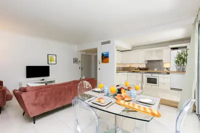 a living room with a couch and a table with food on it at Cristal Croisette YourHostHelper in Cannes