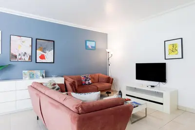 a living room with a couch and a tv at Cristal Croisette YourHostHelper in Cannes