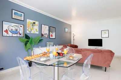 a living room with a table and a couch at Cristal Croisette YourHostHelper in Cannes
