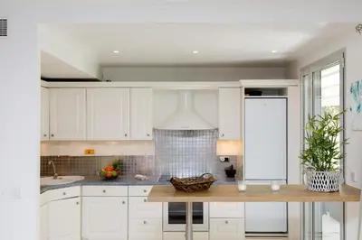 a kitchen with white cabinets and a counter top at Cristal Croisette YourHostHelper in Cannes