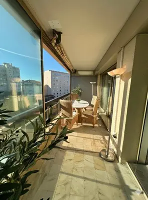 a room with a desk with a television and a balcony at B038 Spacieux Appartement proche Croisette parking in Cannes