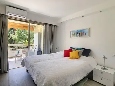 a bedroom with a large bed and a balcony at Appartement 2 Pièces,Cannes, Résidence Le Merival in Cannes