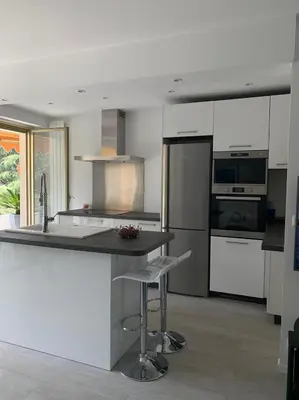 a kitchen with white cabinets and a island with a bar stool at Appartement 2 Pièces,Cannes, Résidence Le Merival in Cannes