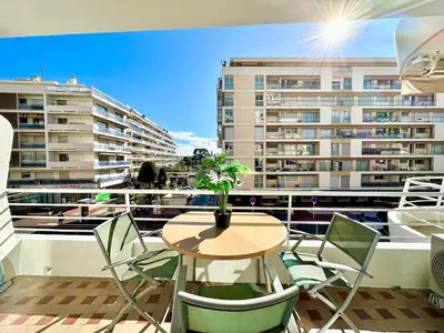 a balcony with a table and chairs and a building at Alexendre 3 Elégant Studio Centre Cannes proche Palais des festivals in Cannes