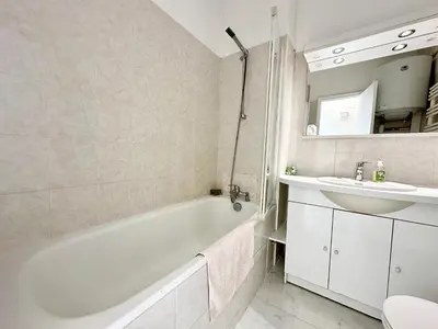 a bathroom with a white tub and a sink at Alexendre 3 Elégant Studio Centre Cannes proche Palais des festivals in Cannes