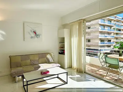 a living room with a couch and a large window at Alexendre 3 Elégant Studio Centre Cannes proche Palais des festivals in Cannes