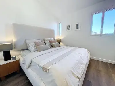 a large white bed in a room with a window at 79m2 Penthouse, Palais et plages à 400m rooftop in Cannes