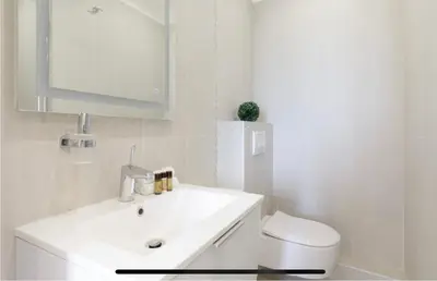 a white bathroom with a sink and a toilet at Palais des Festival view in Cannes