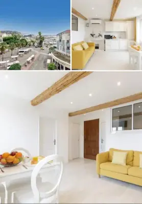 a living room with a yellow couch and a table at Palais des Festival view in Cannes