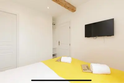 a bedroom with a bed with a television on the wall at Palais des Festival view in Cannes