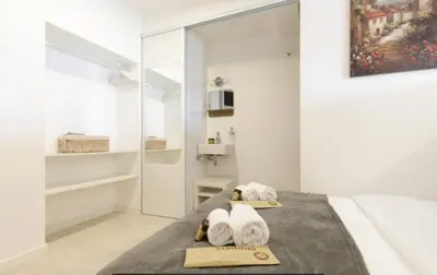 a bedroom with a bed with towels and a mirror at Palais des Festival view in Cannes