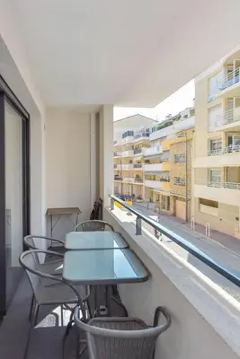 a balcony with tables and chairs and a building at Modern apartment with swimming pool in Cannes