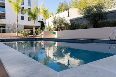 a swimming pool in front of a building at Modern apartment with swimming pool in Cannes