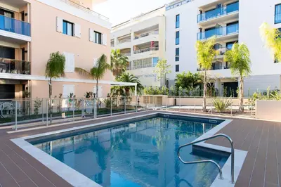 a swimming pool in front of a building at Modern apartment with swimming pool in Cannes
