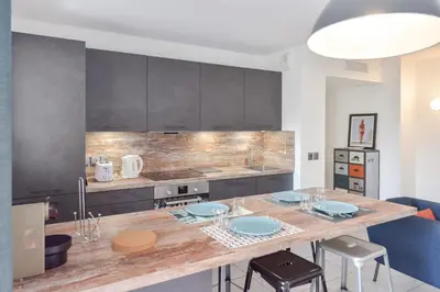 a kitchen with a table with blue plates on it at Modern apartment with swimming pool in Cannes