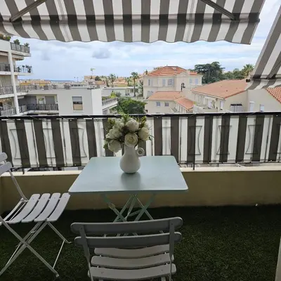 a vase of flowers sitting on a table on a balcony at Studio Cannes le Val D'or Chez Lisa in Cannes