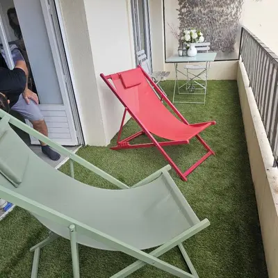 a red chair and a table on a balcony at Studio Cannes le Val D'or Chez Lisa in Cannes