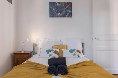 a bedroom with a bed with towels on it at Couronne de Joséphine - 10 mn à pied du Palais et plages, charme et authenticité in Cannes