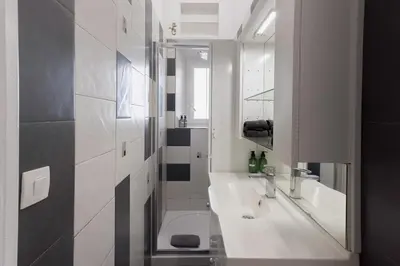 a white bathroom with a sink and a mirror at Couronne de Joséphine - 10 mn à pied du Palais et plages, charme et authenticité in Cannes