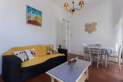a living room with a couch and a table at Couronne de Joséphine - 10 mn à pied du Palais et plages, charme et authenticité in Cannes