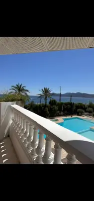 a balcony with a white railing next to a swimming pool at Cannes appartement vue mer , piscine in Cannes