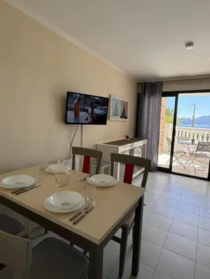 a dining room with a table with chairs and a television at Cannes appartement vue mer , piscine in Cannes