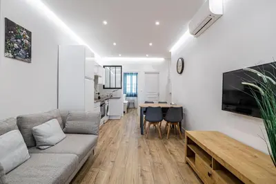 a living room with a couch and a table at LE BAMBOO idéalement situé en centre-ville, pour familles ou petits groupes in Cannes