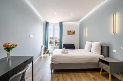 a small bedroom with a bed and a desk at LE BAMBOO idéalement situé en centre-ville, pour familles ou petits groupes in Cannes
