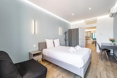 a bedroom with a bed and a desk and a couch at LE BAMBOO idéalement situé en centre-ville, pour familles ou petits groupes in Cannes