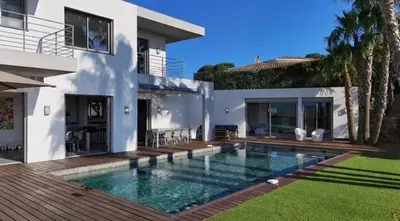 a villa with a swimming pool in front of a house at Villa CANNES in Cannes