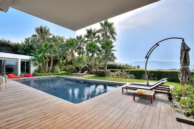 a backyard with a swimming pool and a wooden deck at Villa CANNES in Cannes