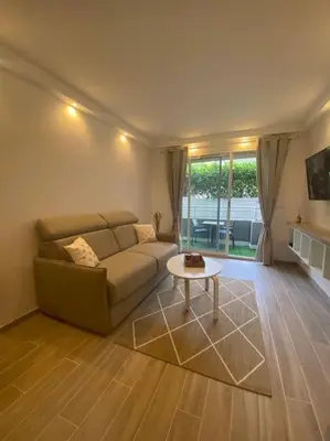 a living room with a couch and a table at Appartement neuf Pointe Croisette, 50 m de la mer in Cannes