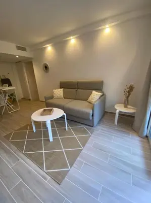 a living room with a couch and a table at Appartement neuf Pointe Croisette, 50 m de la mer in Cannes