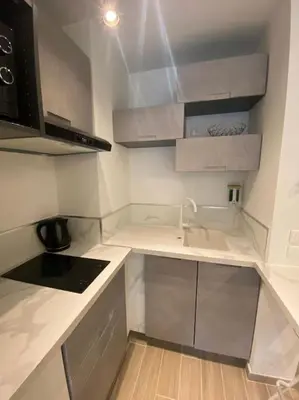 a small kitchen with white counters and a sink at Appartement neuf Pointe Croisette, 50 m de la mer in Cannes