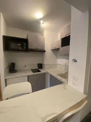 a white kitchen with a sink and a microwave at Appartement neuf Pointe Croisette, 50 m de la mer in Cannes