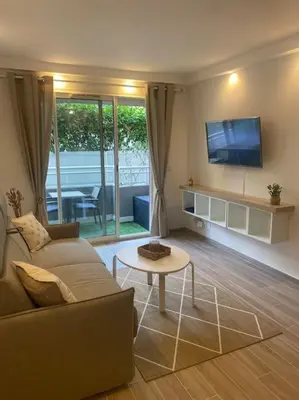 a living room with a couch and a table at Appartement neuf Pointe Croisette, 50 m de la mer in Cannes