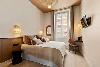 a bedroom with a bed and a window at Le Bonheur - 5mins Palais des Festivals in Cannes