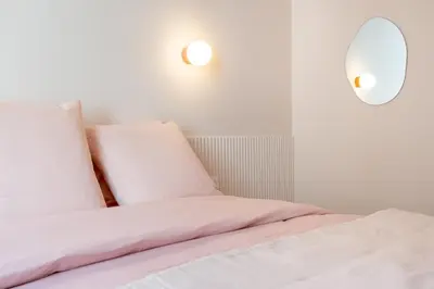 a bedroom with two beds with white sheets and a mirror at Le Bonheur - 5mins Palais des Festivals in Cannes
