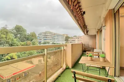 a balcony with a table and benches on a building at Appartement proche des Plages et du Palais in Cannes