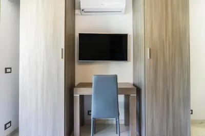 a room with a desk and a tv and a blue chair at Isola Bella by Connexion in Cannes
