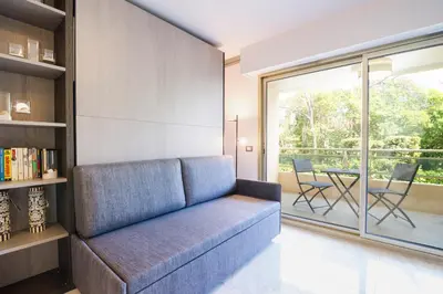 a living room with a couch and a table with chairs at Isola Bella by Connexion in Cannes