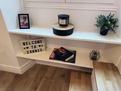 a shelf in a hallway with books and signs at Cannes Croisette Festival Plage Mer in Cannes